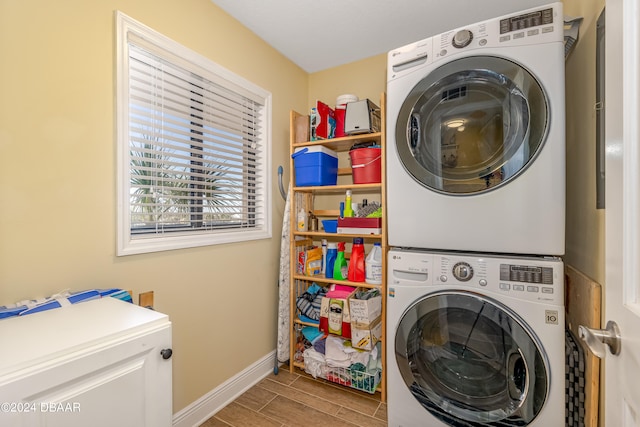 laundry room with stacked washing maching and dryer and wood-type flooring