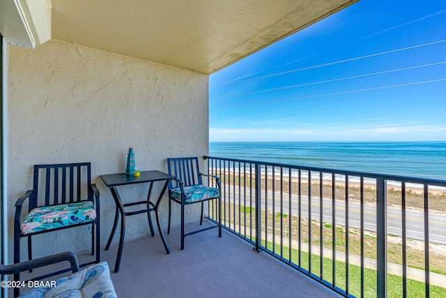 balcony featuring a water view and a view of the beach