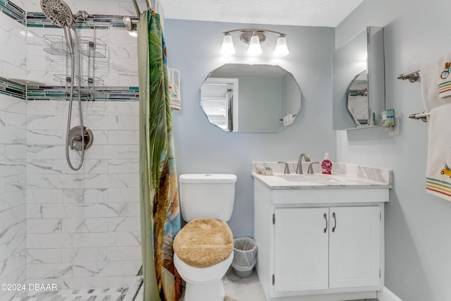 bathroom featuring a tile shower, vanity, and toilet