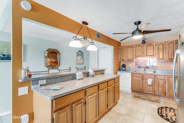 kitchen with white dishwasher, sink, hanging light fixtures, ceiling fan, and a textured ceiling