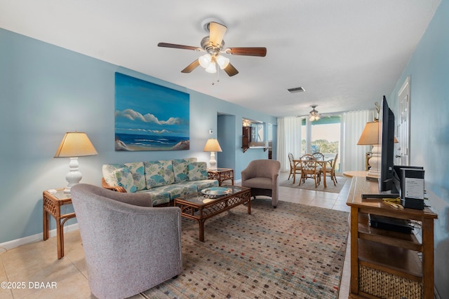 living area with a ceiling fan, tile patterned flooring, visible vents, and baseboards