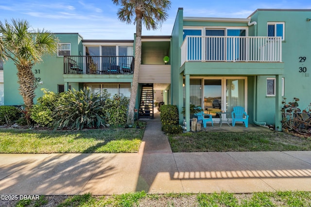 townhome / multi-family property featuring stairway and stucco siding