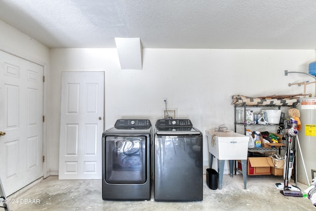 clothes washing area with separate washer and dryer, a textured ceiling, and sink