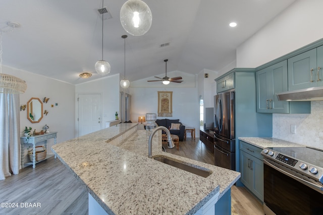 kitchen featuring appliances with stainless steel finishes, sink, hardwood / wood-style flooring, an island with sink, and vaulted ceiling