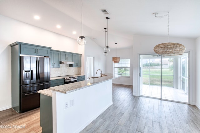 kitchen with an island with sink, light stone counters, appliances with stainless steel finishes, and decorative light fixtures