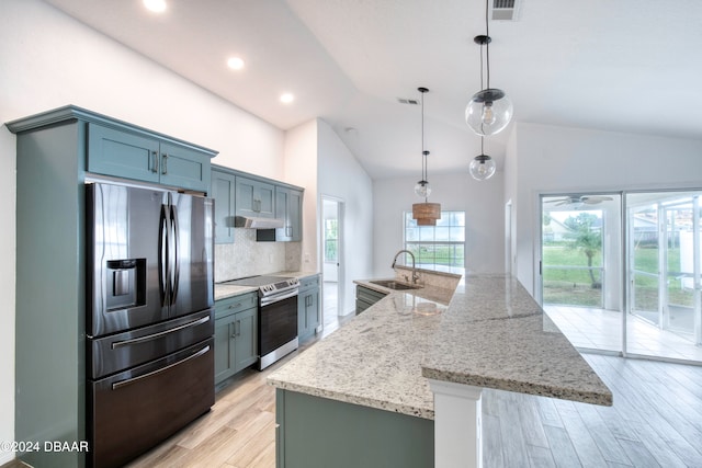 kitchen featuring light hardwood / wood-style floors, sink, a large island with sink, appliances with stainless steel finishes, and pendant lighting