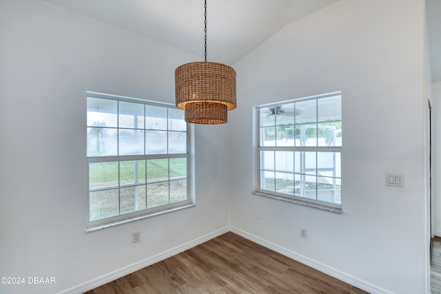 empty room featuring hardwood / wood-style floors, a healthy amount of sunlight, and vaulted ceiling