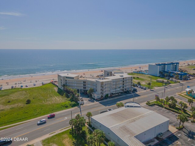 drone / aerial view featuring a beach view and a water view