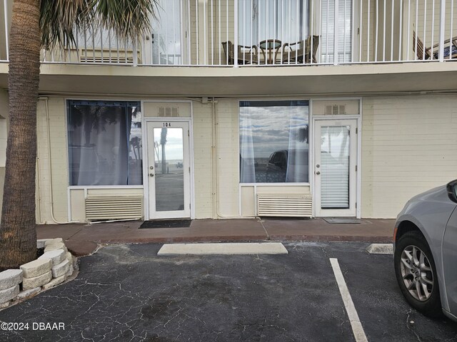 1233 S Atlantic Ave Unit 1040, Daytona Beach, FL 32118 - doorway to property featuring brick siding, a balcony, and uncovered parking