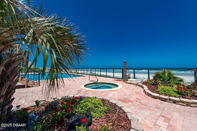 view of pool with a water view, a beach view, and a community hot tub