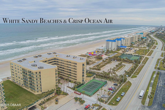 drone / aerial view featuring a water view and a view of the beach