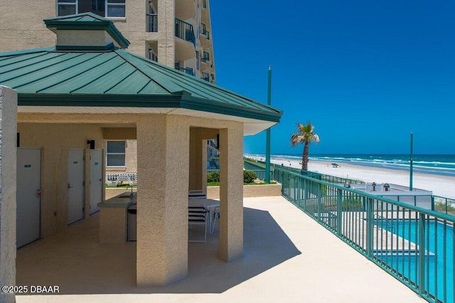 view of community featuring a beach view and a water view