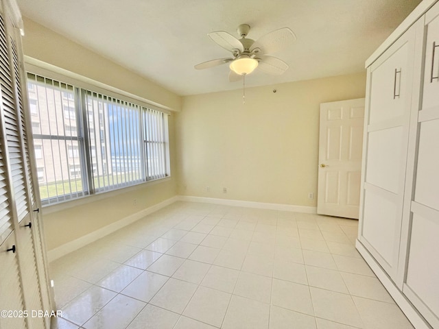 tiled empty room featuring ceiling fan