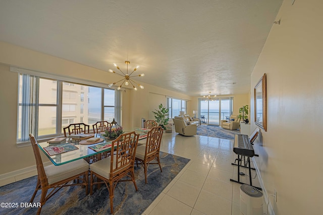 tiled dining area featuring a textured ceiling and an inviting chandelier