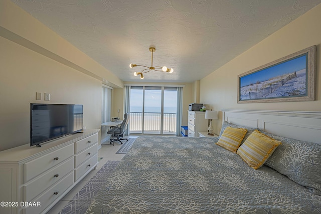 bedroom featuring access to outside, a chandelier, and a textured ceiling