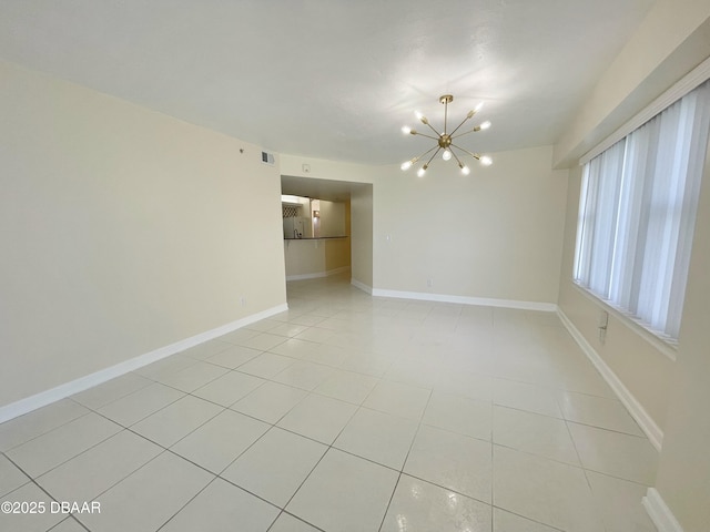 tiled empty room with a chandelier