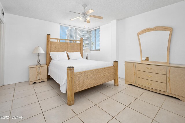 tiled bedroom featuring ceiling fan and a textured ceiling