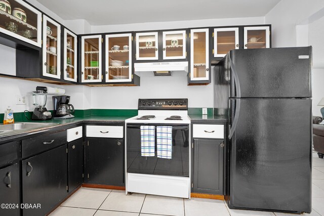 kitchen with black fridge, white range with electric cooktop, light tile patterned floors, and sink