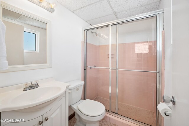 bathroom with toilet, vanity, tile patterned flooring, and a shower with door