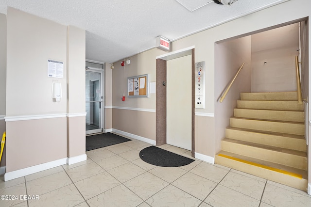 interior space with elevator and a textured ceiling