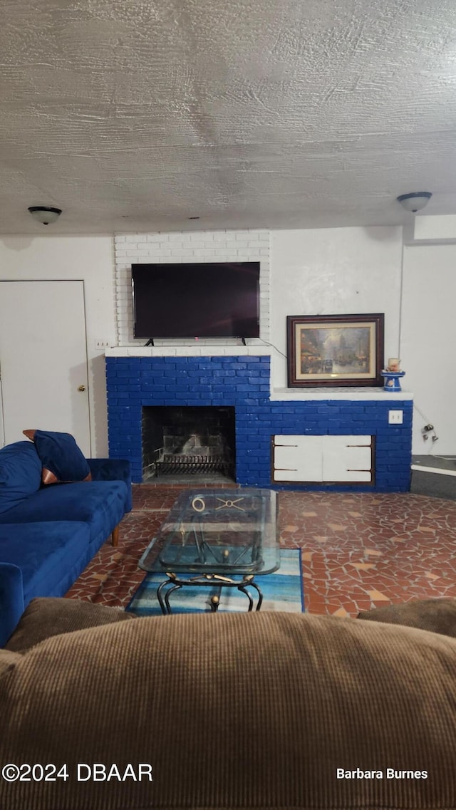 living room featuring a fireplace and a textured ceiling