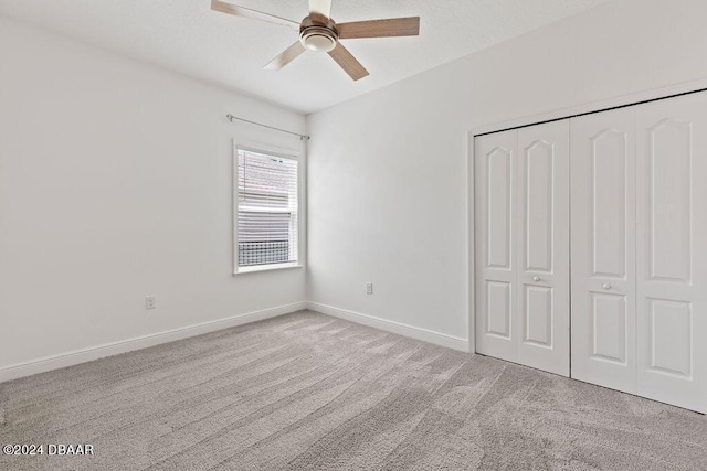 unfurnished bedroom with light colored carpet, a closet, and ceiling fan