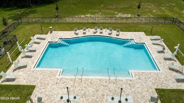 view of swimming pool with a yard and a patio