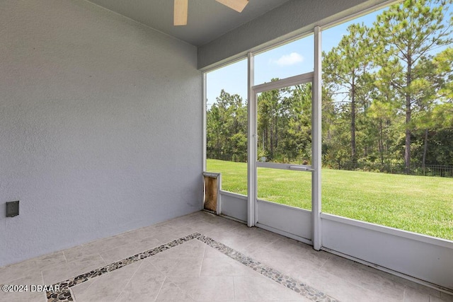 unfurnished sunroom with ceiling fan and a healthy amount of sunlight