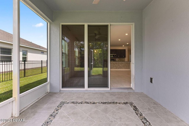 unfurnished sunroom featuring ceiling fan