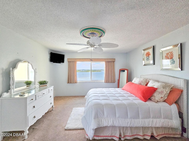 3606 S Peninsula Dr Unit 614, Port Orange, FL 32127 - bedroom with light colored carpet, a textured ceiling, and ceiling fan