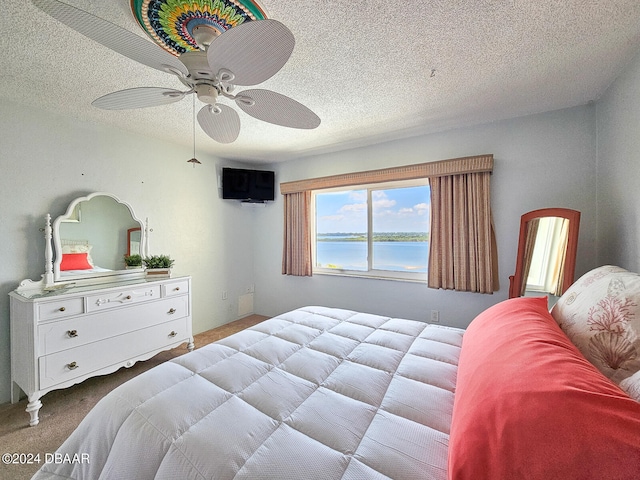 bedroom featuring a textured ceiling, light carpet, and ceiling fan