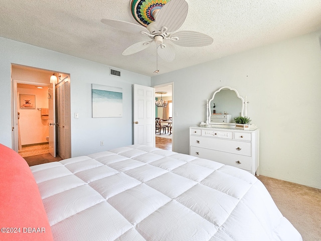 carpeted bedroom with connected bathroom, a textured ceiling, and ceiling fan