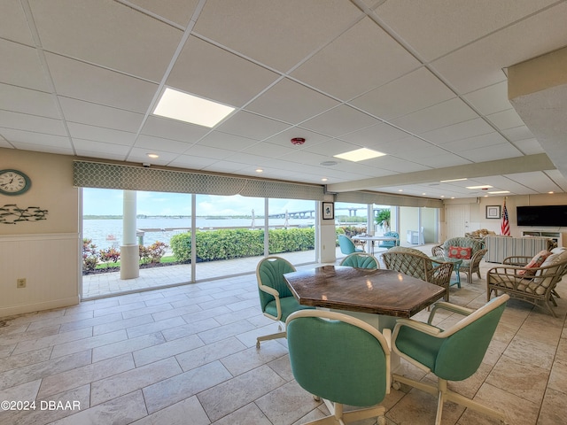 dining area featuring a paneled ceiling and a water view