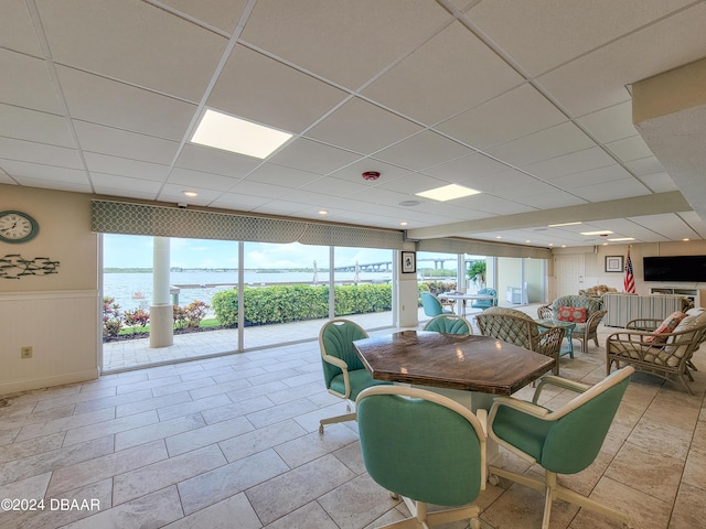3606 S Peninsula Dr Unit 614, Port Orange, FL 32127 - dining space with healthy amount of natural light, a drop ceiling, wainscoting, and a water view