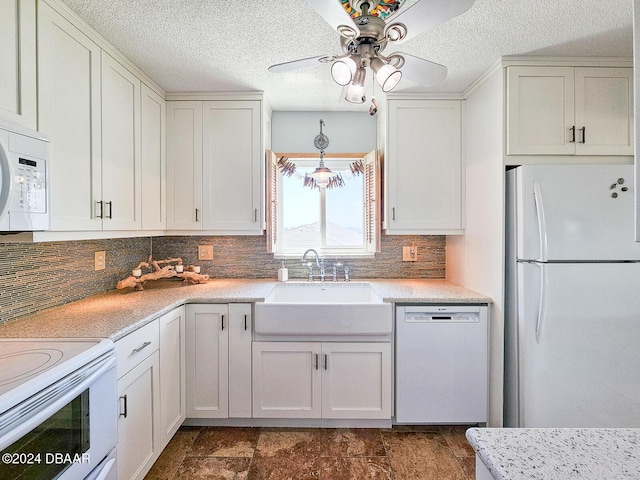 3606 S Peninsula Dr Unit 614, Port Orange, FL 32127 - kitchen with white appliances, a sink, tasteful backsplash, a ceiling fan, and white cabinetry