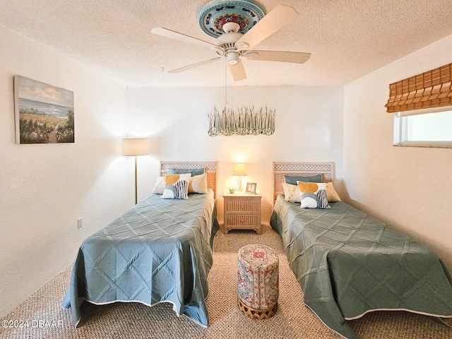 carpeted bedroom featuring ceiling fan and a textured ceiling