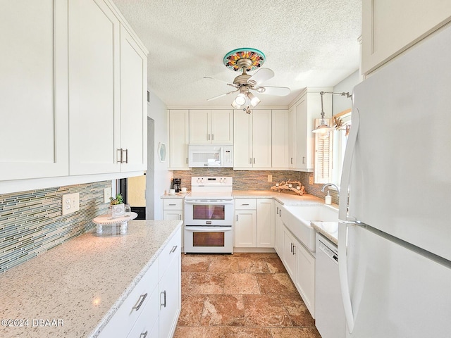 3606 S Peninsula Dr Unit 614, Port Orange, FL 32127 - kitchen featuring white appliances, a ceiling fan, a sink, white cabinetry, and backsplash