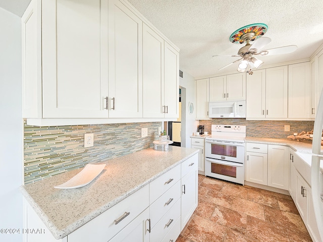 kitchen with light stone countertops, white appliances, white cabinetry, and a textured ceiling