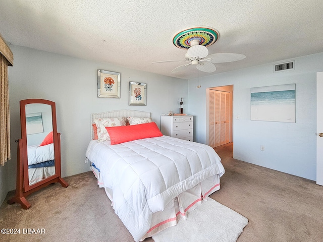 carpeted bedroom featuring a textured ceiling, ceiling fan, and a closet