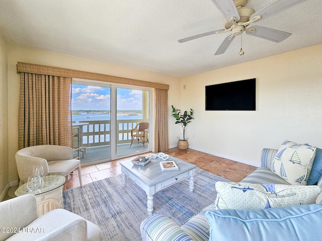 tiled living room with ceiling fan and a textured ceiling