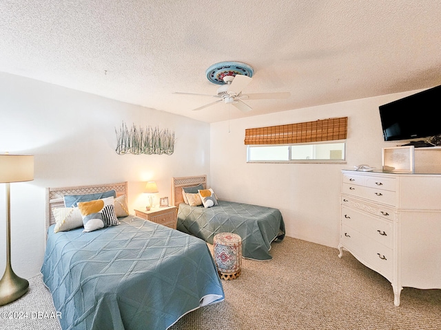 carpeted bedroom featuring ceiling fan and a textured ceiling