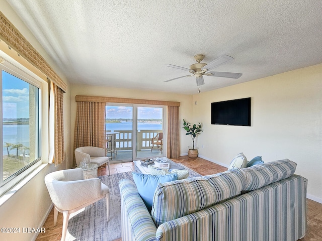 living room featuring wood-type flooring, a textured ceiling, and ceiling fan