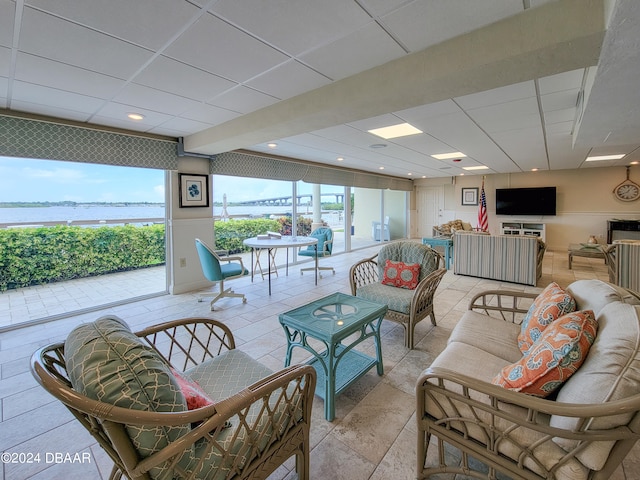 living room with a paneled ceiling and a water view