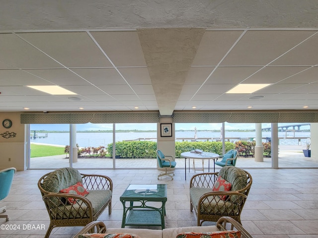 3606 S Peninsula Dr Unit 614, Port Orange, FL 32127 - living room featuring healthy amount of natural light, a water view, and a drop ceiling