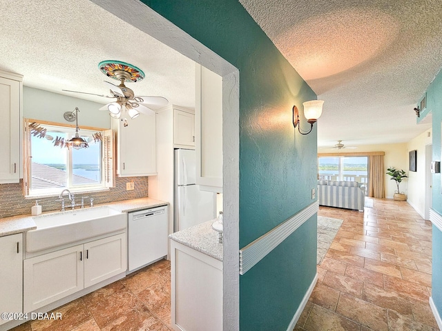 3606 S Peninsula Dr Unit 614, Port Orange, FL 32127 - kitchen with ceiling fan, white appliances, a textured ceiling, decorative backsplash, and stone tile flooring