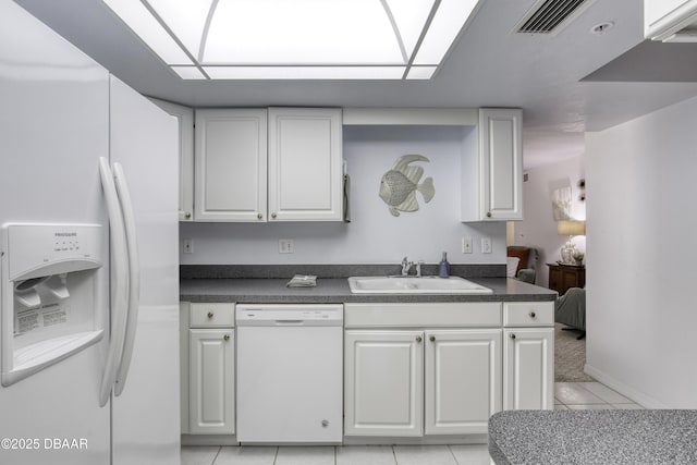 1 John Anderson Dr Unit 317, Ormond Beach, FL 32176 - kitchen featuring white appliances, dark countertops, light tile patterned flooring, and white cabinets