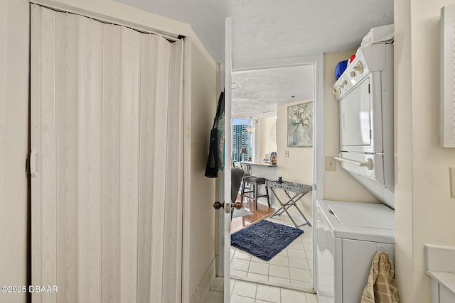 interior space featuring stacked washer / drying machine and light tile patterned floors