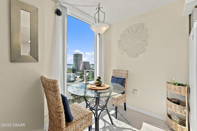 tiled dining area featuring a textured ceiling