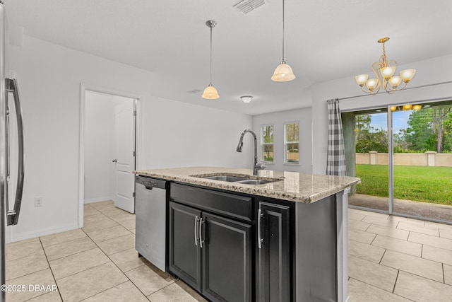 kitchen featuring sink, hanging light fixtures, an island with sink, light stone counters, and stainless steel appliances