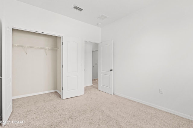 unfurnished bedroom with light carpet and a closet